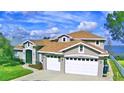 Two-story house with a large yard, lake view and a two-car garage at 2119 Kirkland Lake Dr, Auburndale, FL 33823