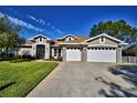 Two-story house with a three-car garage and landscaped lawn at 2119 Kirkland Lake Dr, Auburndale, FL 33823
