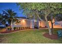 Well-maintained house with a landscaped yard and walkway at night at 2119 Kirkland Lake Dr, Auburndale, FL 33823
