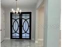Well-lit entryway with stylish double doors and marble-look tile flooring at 2510 Lakefront Dr, Lake Wales, FL 33898