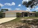 Charming single-story home featuring a two-car garage, neutral paint, and a well-manicured lawn at 2772 Indian Pipes Trl, Frostproof, FL 33843