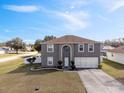 Two-story house with gray siding, two-car garage, and landscaped lawn at 343 Drum Ct, Kissimmee, FL 34759