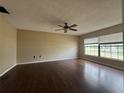 Spacious living room with hardwood floors, neutral walls, ceiling fan, and large windows offering ample natural light at 3710 Black Jack Ct, Lake Wales, FL 33898