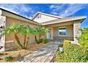 House entrance with walkway, palm trees, and stone accents at 537 Pond Cypress Ct, Auburndale, FL 33823