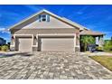 Three-car garage with paver driveway and stone accents at 537 Pond Cypress Ct, Auburndale, FL 33823