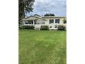 Charming home with a covered front porch, lush lawn, and mature landscaping, creating a welcoming curb appeal at 922 S Lake Reedy Blvd, Frostproof, FL 33843