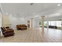 Spacious living room with tile floors, fireplace, and decorative columns, perfect for entertaining at 1121 Sunset Dr, Lake Wales, FL 33853
