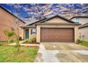 Tan house with brown garage door and landscaping at 1713 Yellow Trl, Lakeland, FL 33801