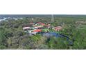 Aerial view of the condo community showing the buildings, a pond with a fountain, and surrounding landscape at 2002 Granada Ct # 1, Lake Wales, FL 33898