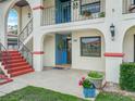 Inviting condo entrance with a pop of color from the red stairs and potted flowers at 2002 Granada Ct # 1, Lake Wales, FL 33898
