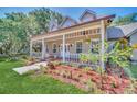 House exterior showcasing a wraparound porch and well-manicured lawn at 21113 Kissimmee Shores Rd, Lake Wales, FL 33898