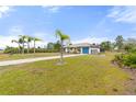 Single-story home with palm trees and a long driveway at 2330 Park Ave, Indian Lake Estates, FL 33855