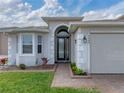 Home's entryway with a charming walkway and landscaping at 4240 Dunmore Dr, Lake Wales, FL 33859