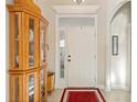 Bright entryway with hardwood floors, wooden cabinet, and red rug at 524 Lake Suzanne Dr, Lake Wales, FL 33859