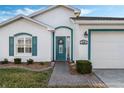 Welcoming front entry with teal door, and brick walkway at 524 Lake Suzanne Dr, Lake Wales, FL 33859