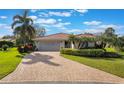 Charming single-story home featuring lush landscaping, a brick driveway, and a two-car garage at 768 Canberra Rd, Winter Haven, FL 33884