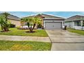 Gray house with stone accents, palm trees, and a spacious driveway at 918 Revere Ave, Haines City, FL 33844