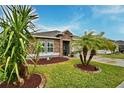 Landscaped front yard with palm trees and drought-tolerant plants at 918 Revere Ave, Haines City, FL 33844