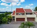Charming exterior featuring a red tile roof, a spacious garage, and a well-manicured landscape at 1 Casarena Ct, Winter Haven, FL 33881