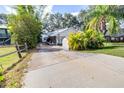 Charming single-story home with a spacious driveway, shed, and lush tropical landscaping at 1048 Sunset Trail, Babson Park, FL 33827