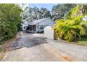 Charming single-story home with a spacious driveway, shed, and lush tropical landscaping at 1048 Sunset Trail, Babson Park, FL 33827