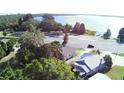 Aerial view of a house near a lake, surrounded by trees and a road, highlighting the scenic location at 1155 S Lake Shore Way, Lake Alfred, FL 33850