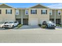 Close up view of a townhome showcasing a neutral color scheme and attached garage at 1157 Blue Jay Dr, Davenport, FL 33837