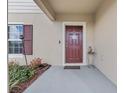 Inviting front porch with a classic red door, tasteful decorations, and a small accent table at 177 Piave St, Haines City, FL 33844