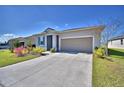 Exterior view of the home showcasing the driveway and tidy front lawn at 200 Summershore Dr, Auburndale, FL 33823