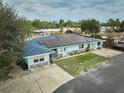 Aerial view of a charming single-story home featuring a bright exterior, solar panels and a well-maintained lawn at 253 Blackwell Villa Cv, Babson Park, FL 33827