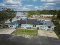 Aerial view of a cute single-story home featuring solar panels, a bright exterior, and a view of the community docks at 253 Blackwell Villa Cv, Babson Park, FL 33827