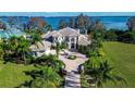 Expansive estate featuring a beautiful home with lush landscaping, circular driveway, and stunning water views at 3312 Eagles Trce, Winter Haven, FL 33884