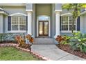 Inviting front entry with decorative glass door and manicured landscaping at 4 Lake Eloise Ln, Winter Haven, FL 33884