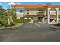 Wide view of the condo highlighting the multiple units, parking, and red tile roof at 400 El Camino Dr # 101, Winter Haven, FL 33884
