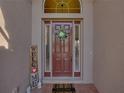 Inviting front door with sidelights, wreath, 'welcome' sign, and a brick entryway at 4033 Phoenician Way, Winter Haven, FL 33884
