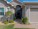 Charming home entrance with brick path, mature landscaping, and covered entryway at 4033 Phoenician Way, Winter Haven, FL 33884