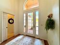 Bright foyer with hardwood floors and a stylish rug, featuring a welcoming entryway and natural light at 4540 Turnberry Ln, Lake Wales, FL 33859