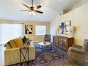Cozy living room with vaulted ceiling, ceiling fan, and comfortable seating area at 4639 Great Blue Heron Dr, Lakeland, FL 33812