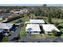Aerial view of a neighborhood featuring well-maintained homes with white tile roofs and green lawns in a sunny environment at 720 Fonda Ct # 54, Lakeland, FL 33803