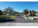 Inviting entrance to a well-kept community featuring lush landscaping, mature trees, and attractive single-story homes at 720 Fonda Ct # 54, Lakeland, FL 33803