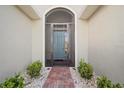 Inviting home entrance featuring a secure screen door and manicured landscaping at 1017 Sawgrass Dr, Winter Haven, FL 33884