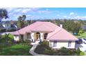 Aerial view of a single-Gathering home with a red tile roof, manicured lawn, and arched entryway at 105 Wyndham Dr, Winter Haven, FL 33884