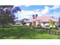 Exterior view of a single-Gathering home with a manicured lawn, arched entryway, and lush landscaping at 105 Wyndham Dr, Winter Haven, FL 33884