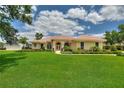 Inviting single-story home featuring a well-manicured lawn, vibrant landscaping, and a terracotta-tiled roof at 105 Wyndham Dr, Winter Haven, FL 33884
