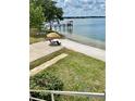Inviting backyard with sandy beach, tiki umbrella, and a private dock on a serene lake at 1050 E Eagle Ave, Eagle Lake, FL 33839