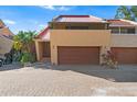 A beautiful home exterior featuring a two-car garage, a brick driveway, and desert-style landscaping at 15 Casarena Ct, Winter Haven, FL 33881