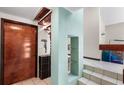 Modern foyer features a wood door, display shelving, tile flooring, and an open staircase to the second floor at 15 Casarena Ct, Winter Haven, FL 33881