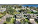 Aerial view of a two story home with mature trees and a serene community lake in background at 1904 Eloise Cove Dr, Winter Haven, FL 33884