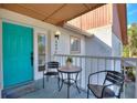 Cozy balcony with seating area and a bright turquoise front door, perfect for relaxing outdoors at 208 Country Ne Ln # 208, Winter Haven, FL 33881