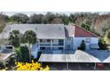 Top-down view of a condominium complex with a carport and mature trees surrounding the building at 208 Country Ne Ln # 208, Winter Haven, FL 33881